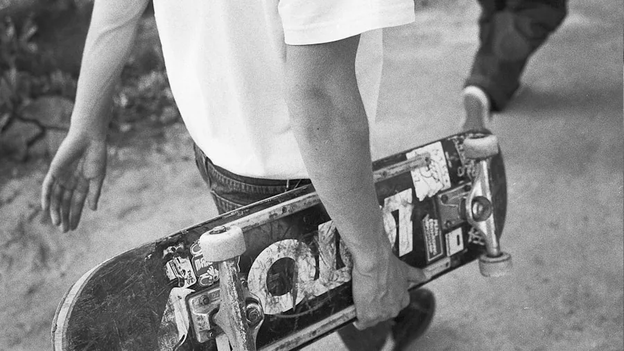 Person inspecting skateboard deck wood grain and ply layers up close