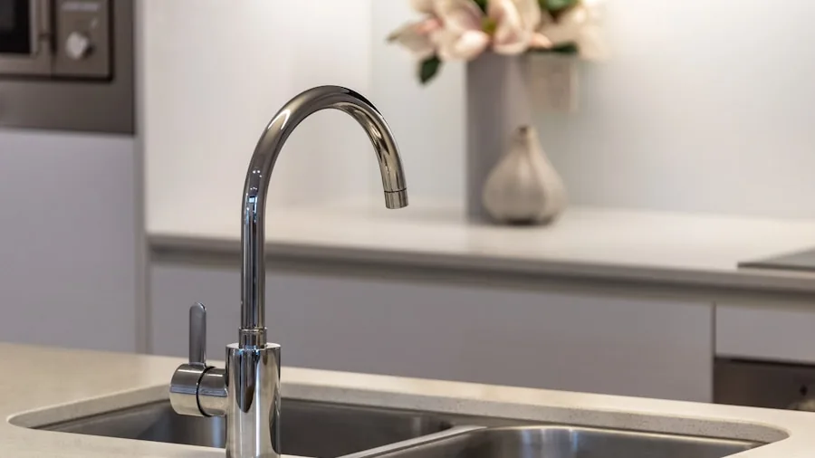 Person installing or examining kitchen sink faucet during home renovation project