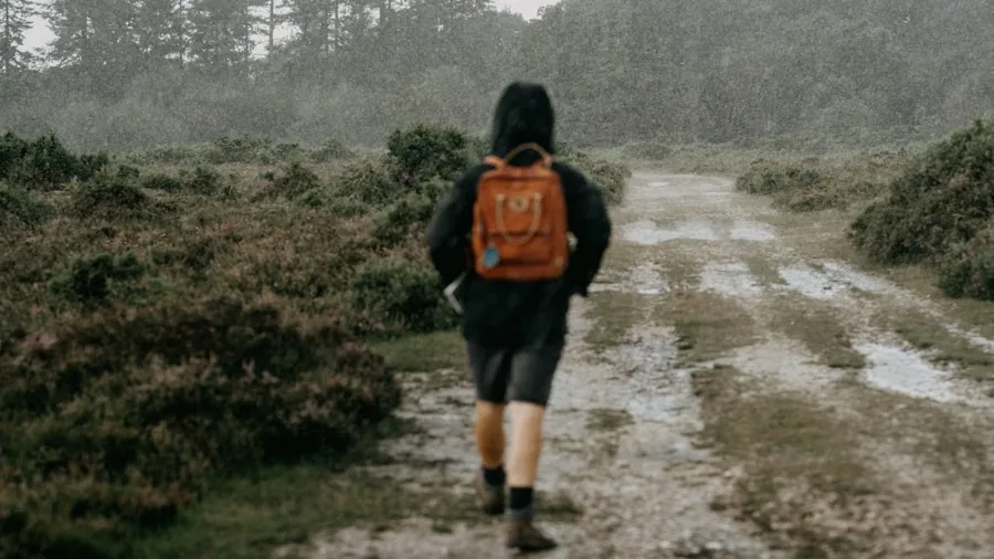 Person jogging outdoors in rainy weather, demonstrating water-resistant athletic gear in action