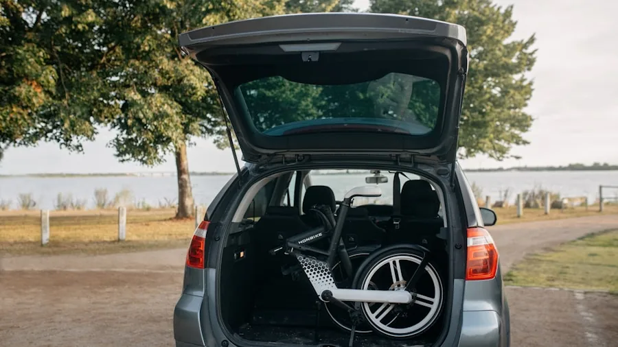 Person loading a folded scooter into a car trunk for convenient transportation and storage