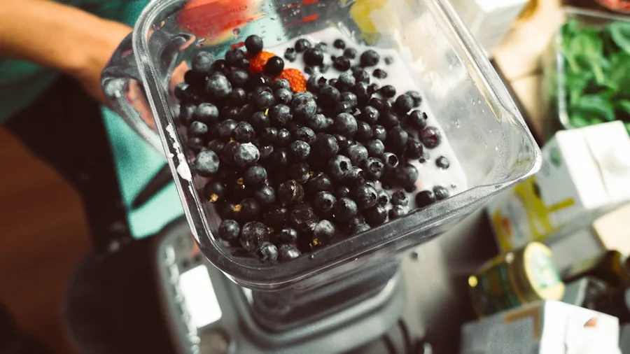 The %product_count% Best Personal Blenders 2 Person making a smoothie with frozen fruit and leafy greens in a kitchen blender