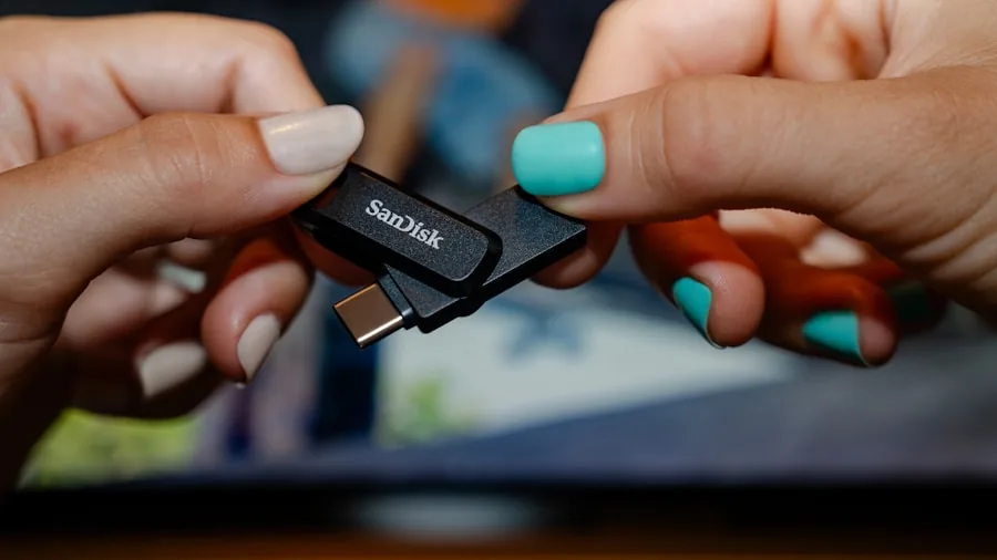 Person managing digital files and cloud storage on computer, organizing photos and documents