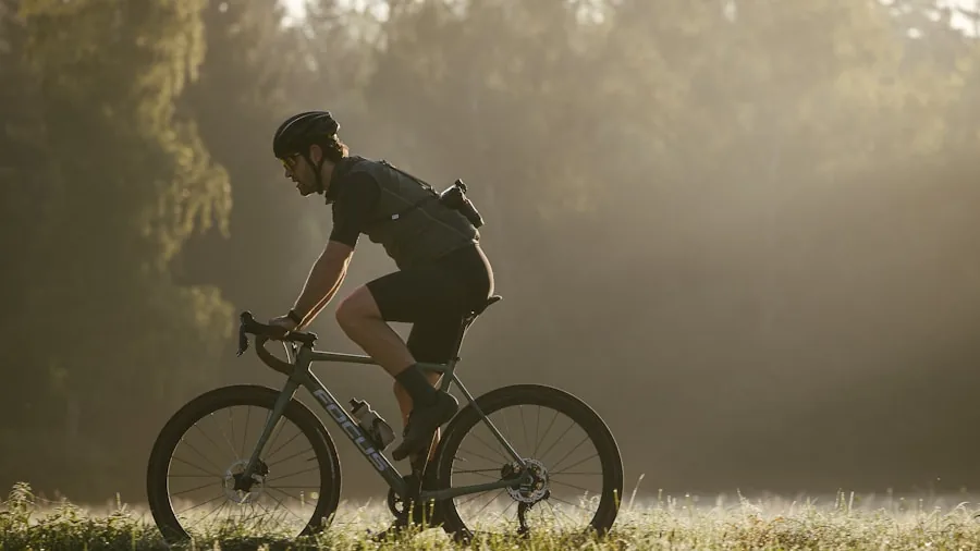 Person on hybrid bike checking drivetrain and gears while riding on urban path