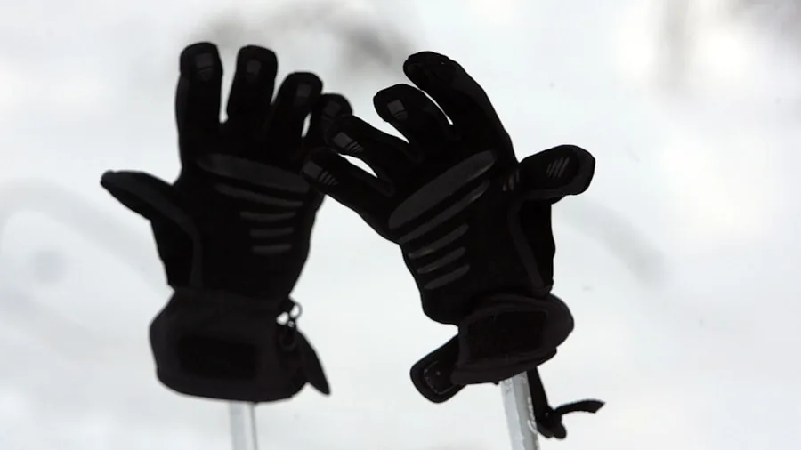 The %product_count% Best Ski Gloves 4 Person on snowy slope checking glove fit and comfort while preparing for skiing
