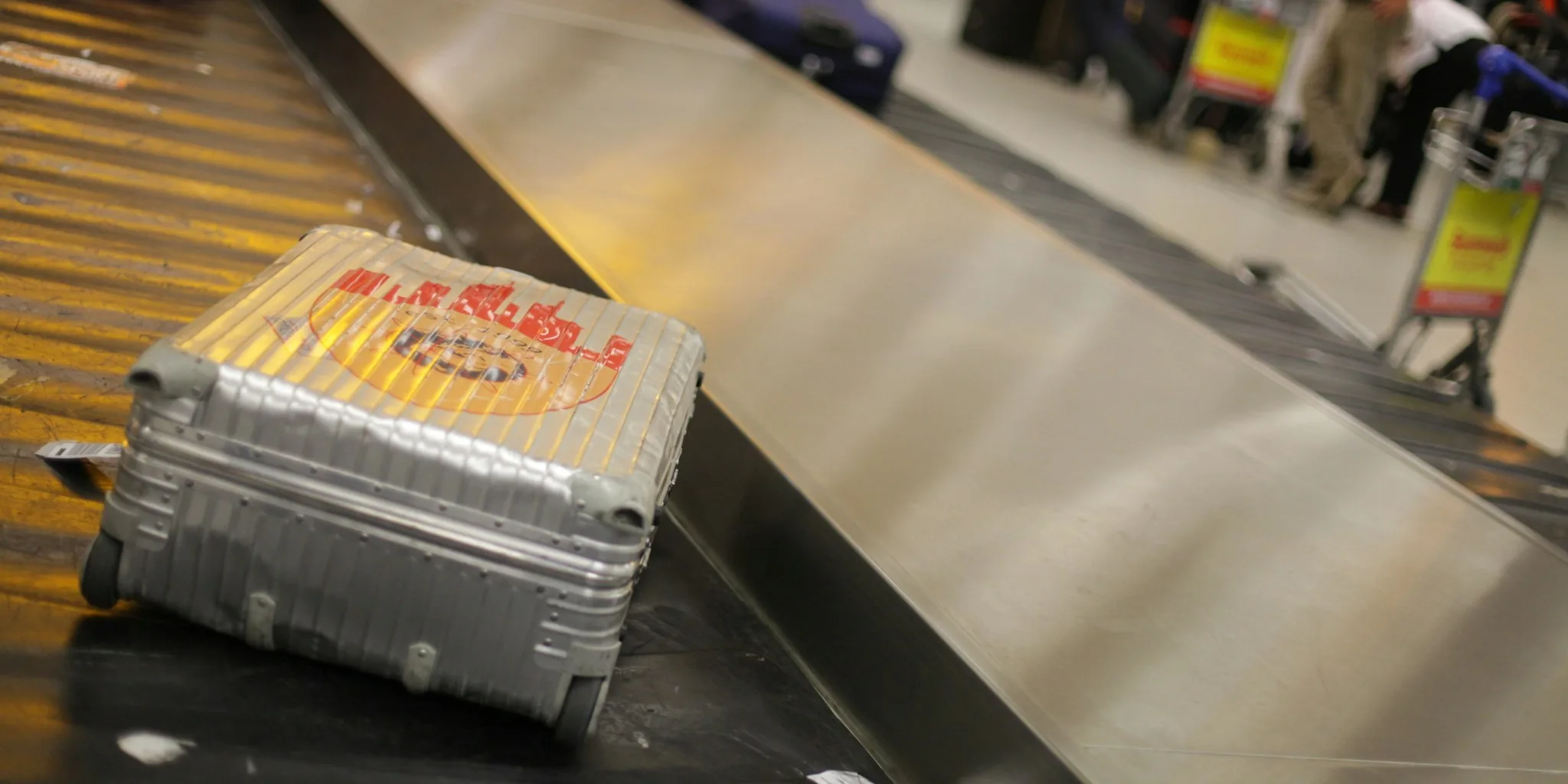 Person organizing and packing checked luggage in airport terminal before flight departure