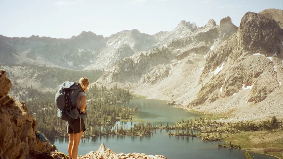 Person organizing and packing hiking gear into a backpack before a trail adventure