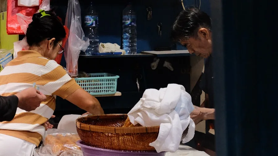 Person organizing and sorting different types of laundry into separate baskets at home