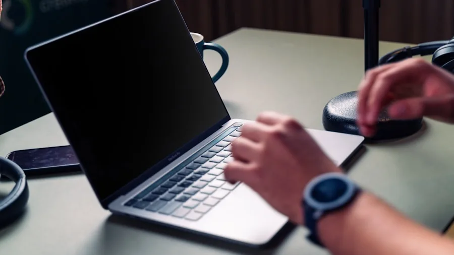 Person pairing Bluetooth speaker with laptop in home office setup