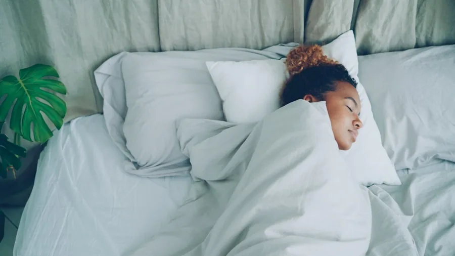 Person peacefully sleeping under a cozy blanket in a comfortable bedroom setting