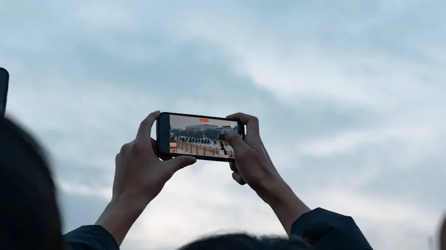 Person playing mobile game on smartphone while sitting outdoors in natural daylight