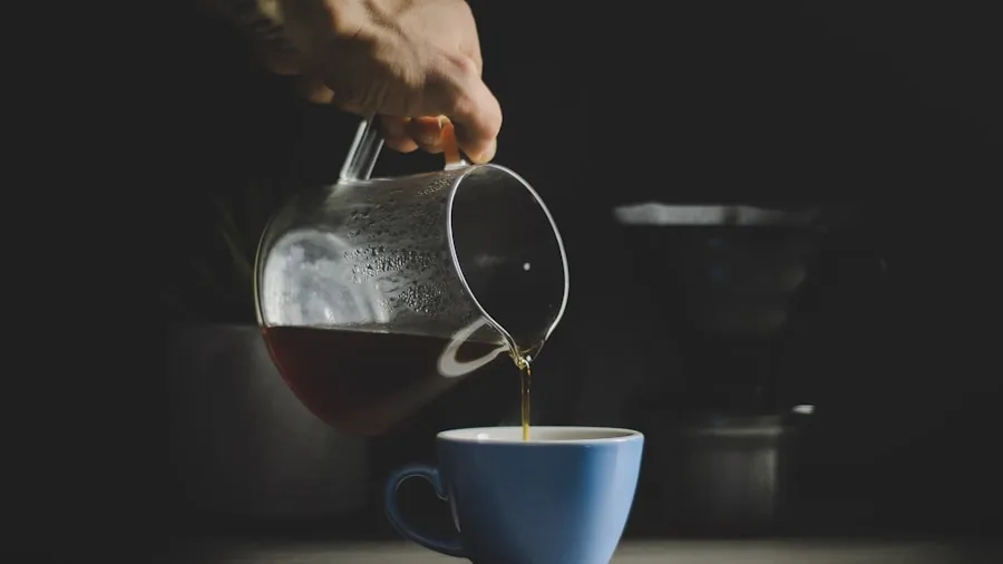 Person pouring freshly brewed coffee into a cup during morning routine in a bright kitchen