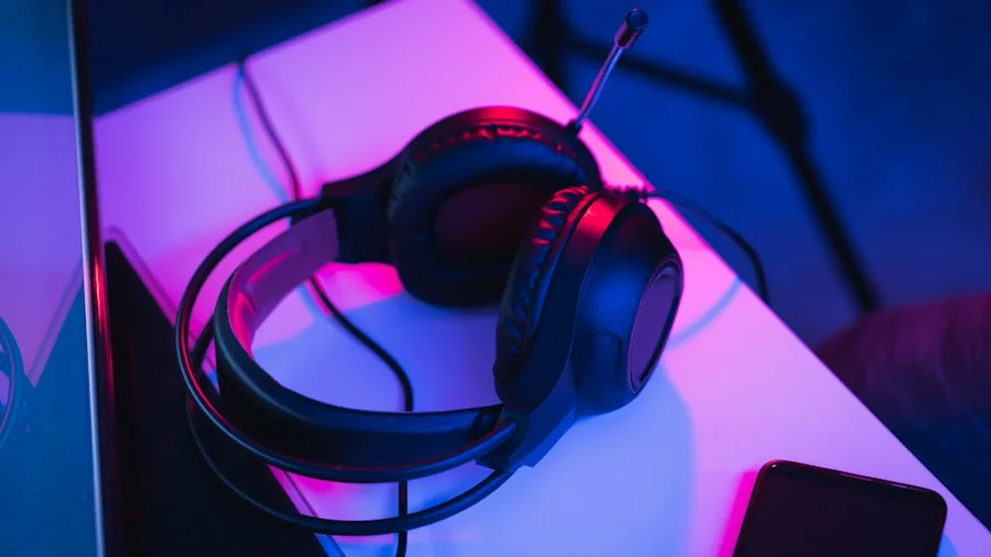 Person researching gaming headphone options on laptop with notepad for budget considerations