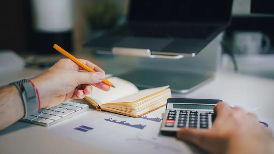 Person reviewing budget and financial decisions at home office desk with laptop and documents