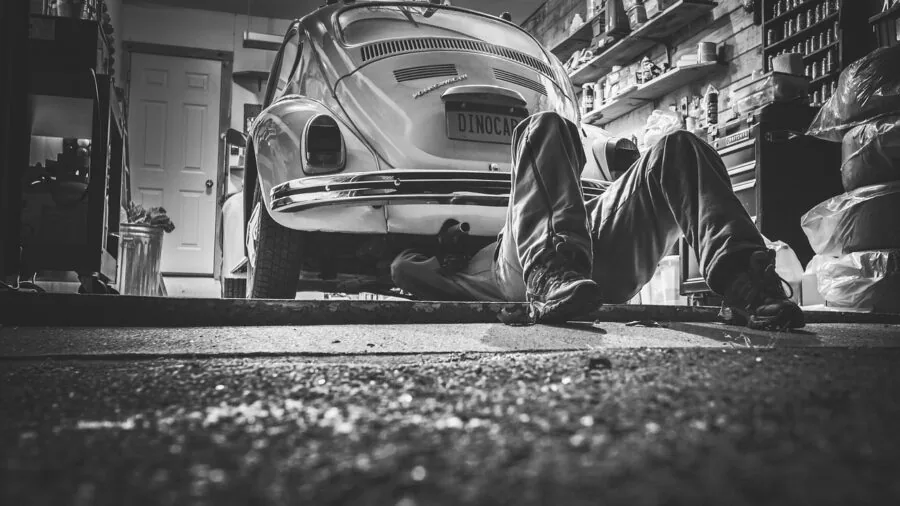 The %product_count% Best Car Batteries 5 Person reviewing car maintenance warranty paperwork and documentation at home