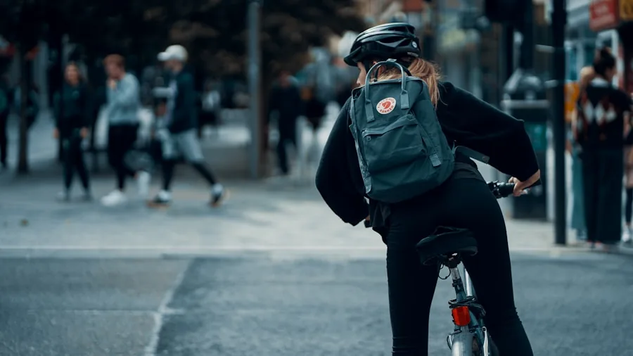Person riding hybrid bike on city street with traffic and buildings in background