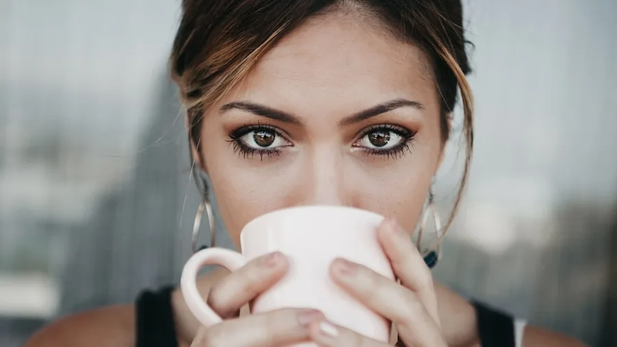 The %product_count% Best Coffee Creamers 2 Person savoring a cup of coffee while contemplating flavor choices during morning routine