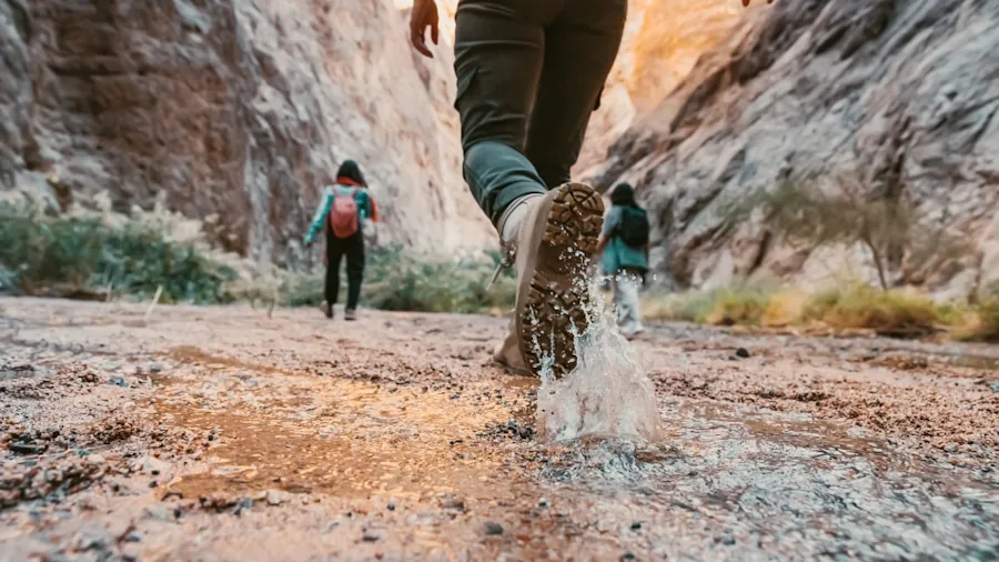 Person selecting hiking boots at outdoor retailer, comparing budget-friendly options for trail hiking