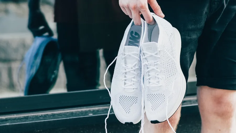 Person selecting running shoes while preparing for workout session