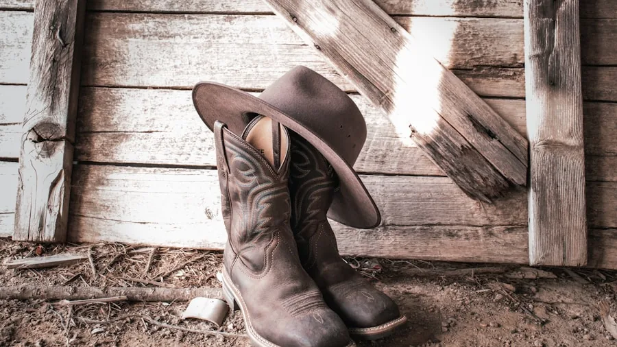 Person sitting down trying on a pair of cowboy boots, examining fit and comfort indoors