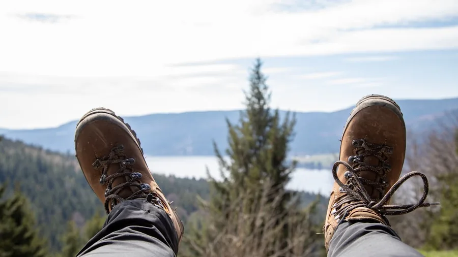 Person sitting on trail fitting hiking boots with socks, checking boot fit before backpacking adventure
