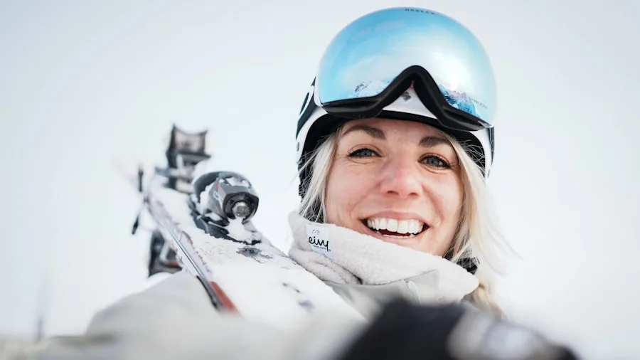 Person skiing downhill wearing properly fitted helmet and goggles on snowy mountain slope