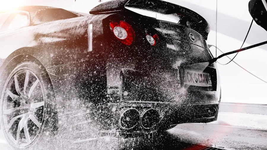 Person spraying water on car during outdoor washing, demonstrating pressure washer use and durability in action
