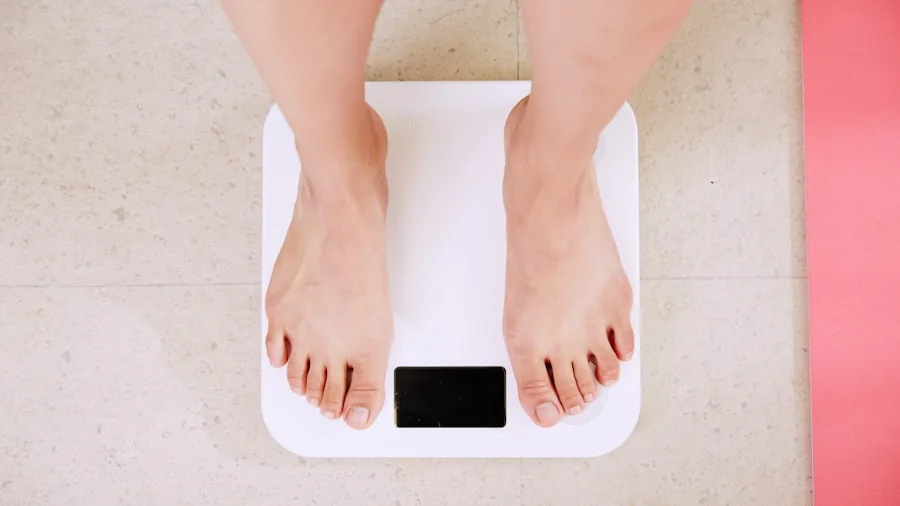 Person standing on bathroom scale checking weight measurement for health tracking
