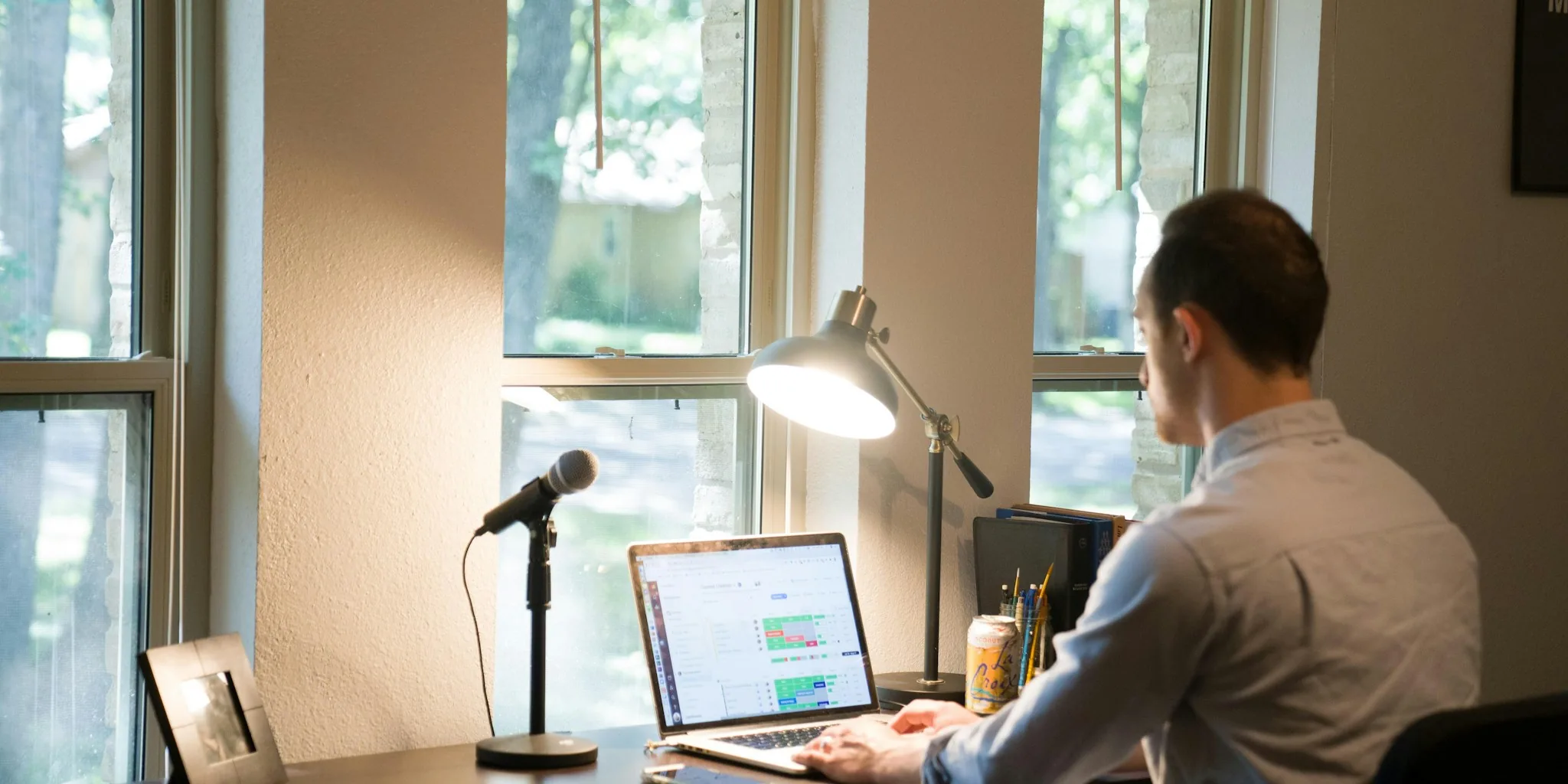 Person typing on laptop at home desk with natural light from window