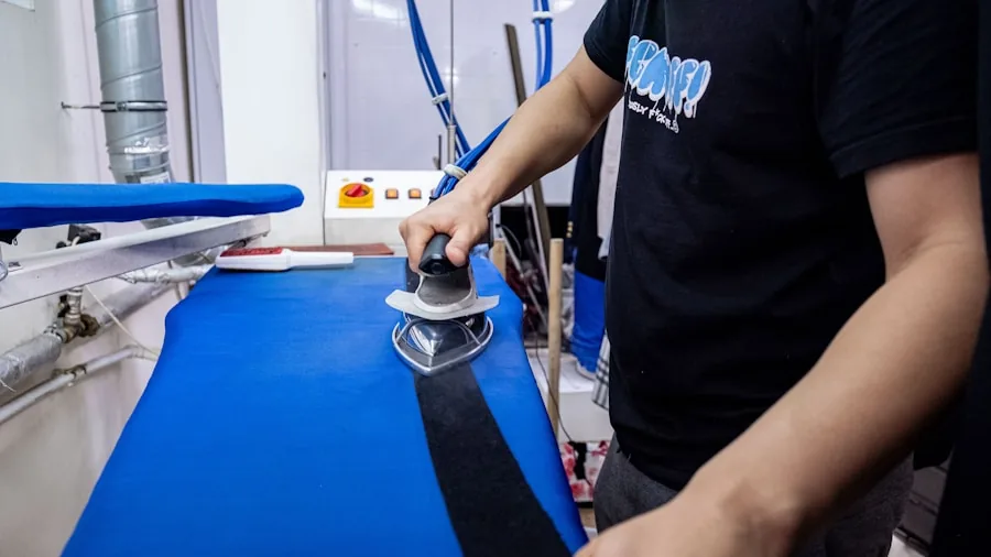 Person using a clothing steamer on denim and heavy fabrics in a home laundry setting