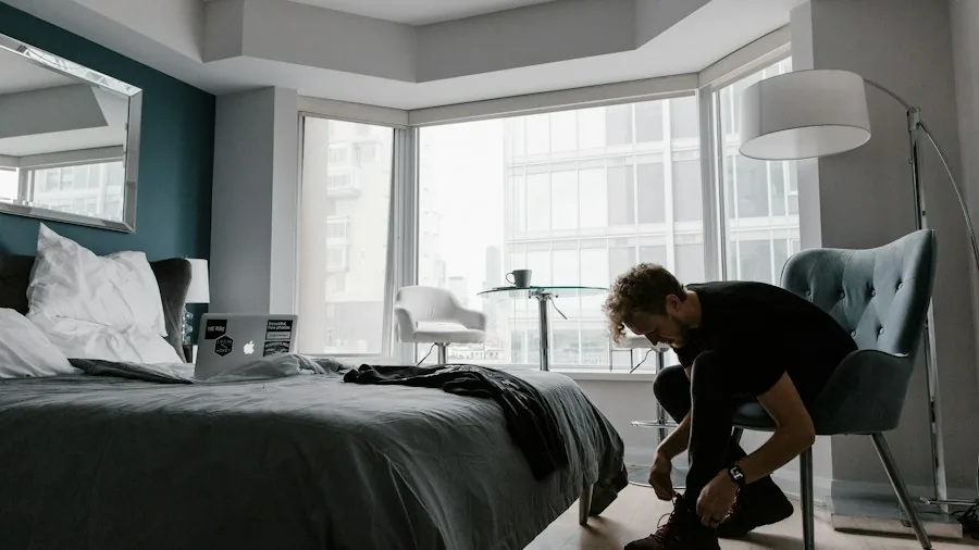 person using upholstery vacuum on bed