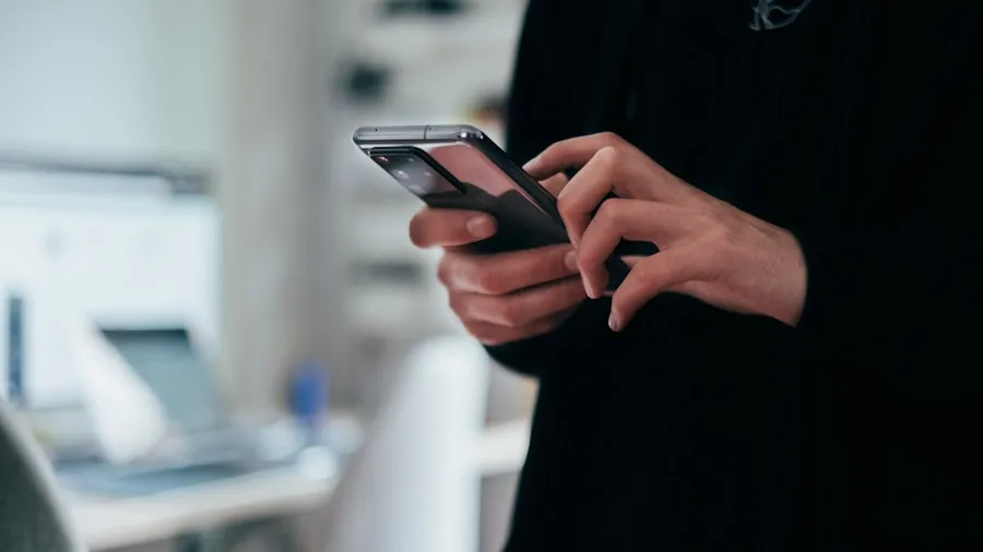 Person viewing health tracking data on smartphone while standing on bathroom scale