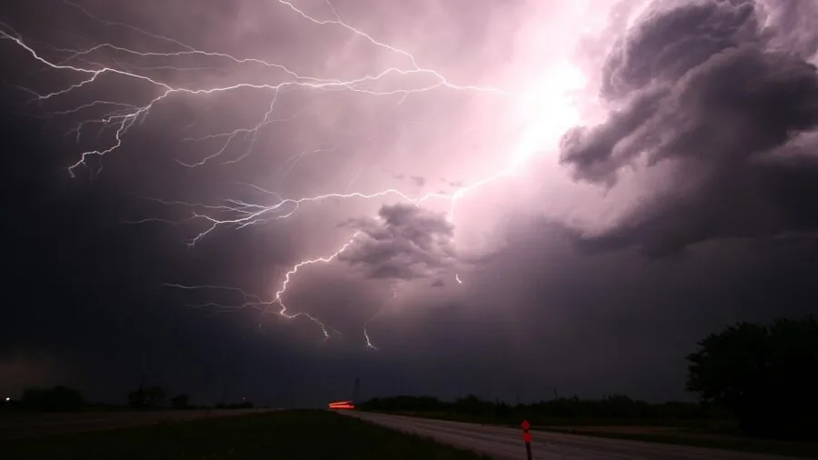 The 9 Best Alarm Clocks 4 Person waking up in bed during a dark storm with lightning visible through window