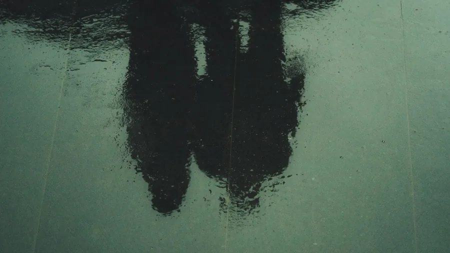 Person walking on wet urban sidewalk with proper footwear grip and traction