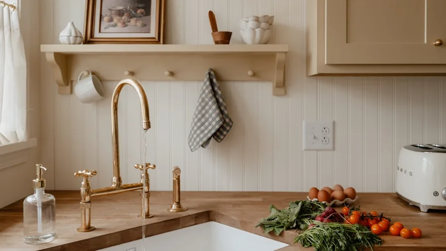 Person wiping down stainless steel kitchen countertop with cloth during regular cleaning and maintenance
