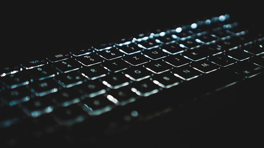 The %product_count% Best Mechanical Keyboards 4 Person working at desk with glowing RGB keyboard in dark room, focused on typing