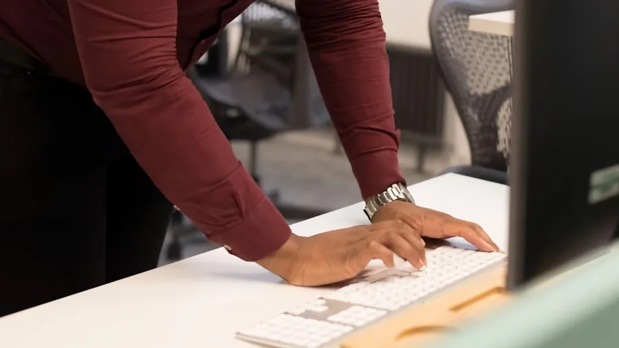 Person working at desk with proper arm positioning and ergonomic posture while typing
