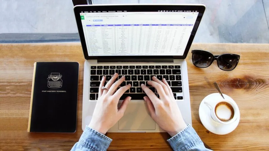 Person working at desk with wireless keyboard in comfortable home office environment