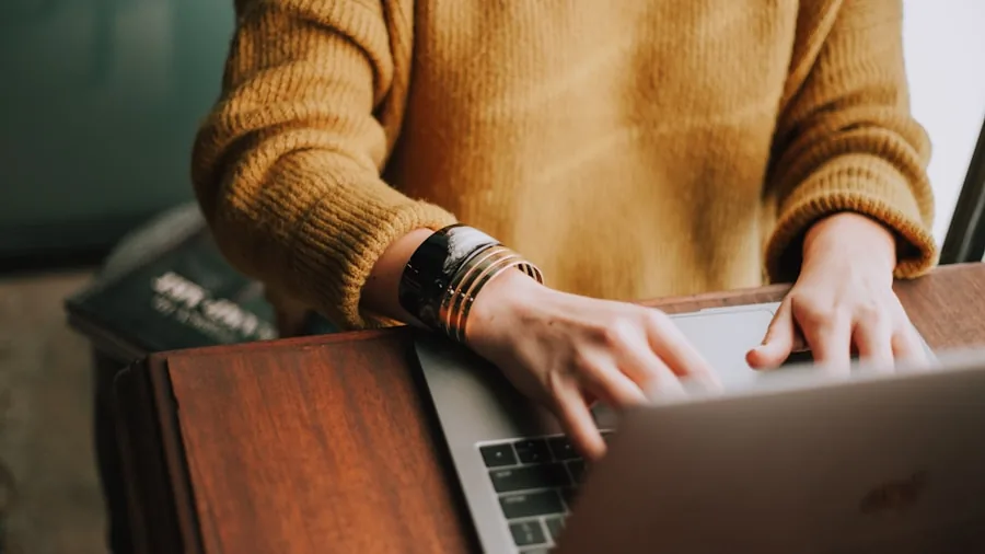 Person working on laptop at desk with focused concentration during business tasks