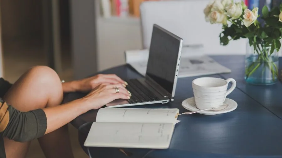 The %product_count% Best Laptops for Home Use 5 Person working on laptop at kitchen table in bright, comfortable home setting with natural light