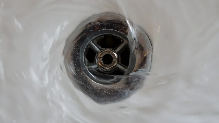 Person wrapping themselves in a soft towel after showering in a bright, well-ventilated bathroom.