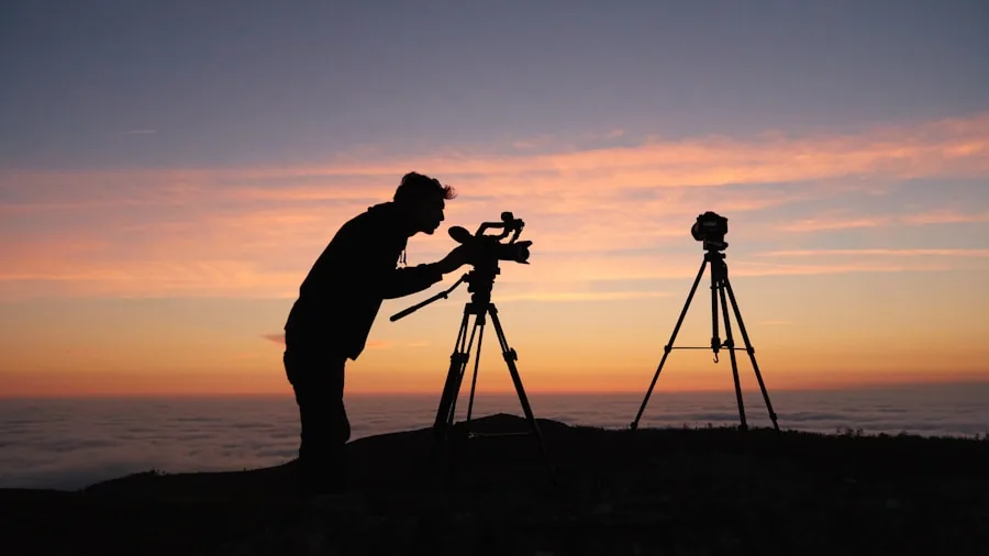 The %product_count% Best Tripods 3 Photographer positioning tripod head while composing landscape shot in natural outdoor setting