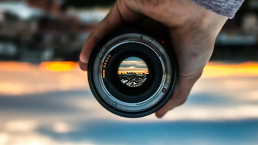 Photographer using telephoto lens to capture distant landscape scenery