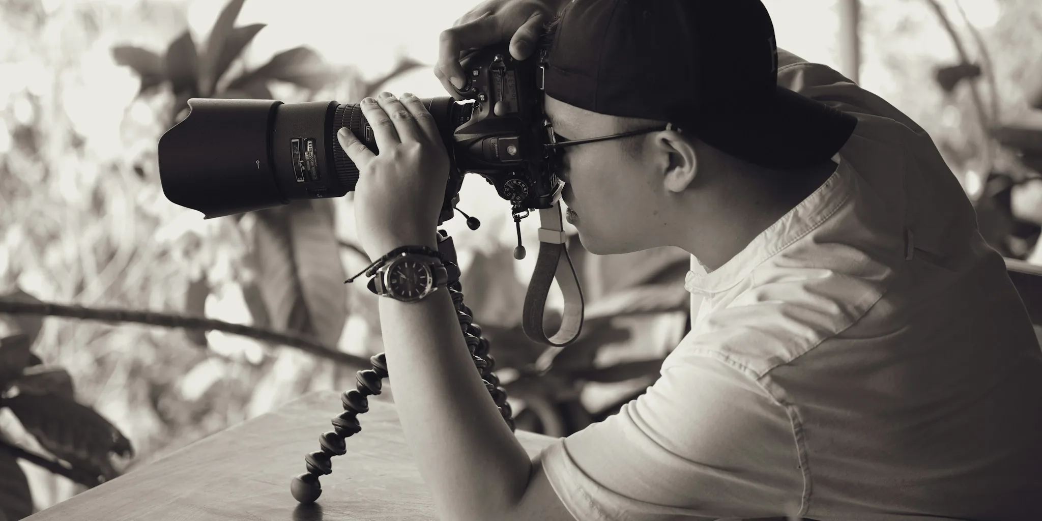Photographer using tripod to capture outdoor landscape with professional camera