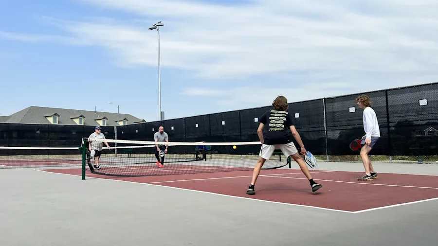 Players in action on outdoor pickleball court with hard playing surface