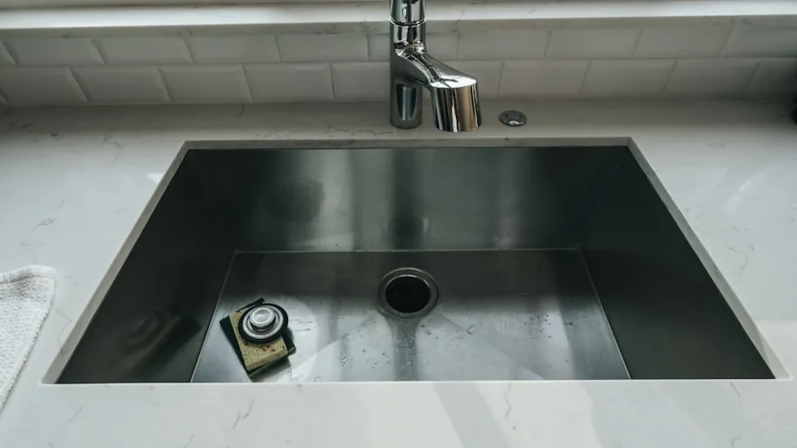 Plumber installing pipes and fixtures under kitchen sink during home renovation project