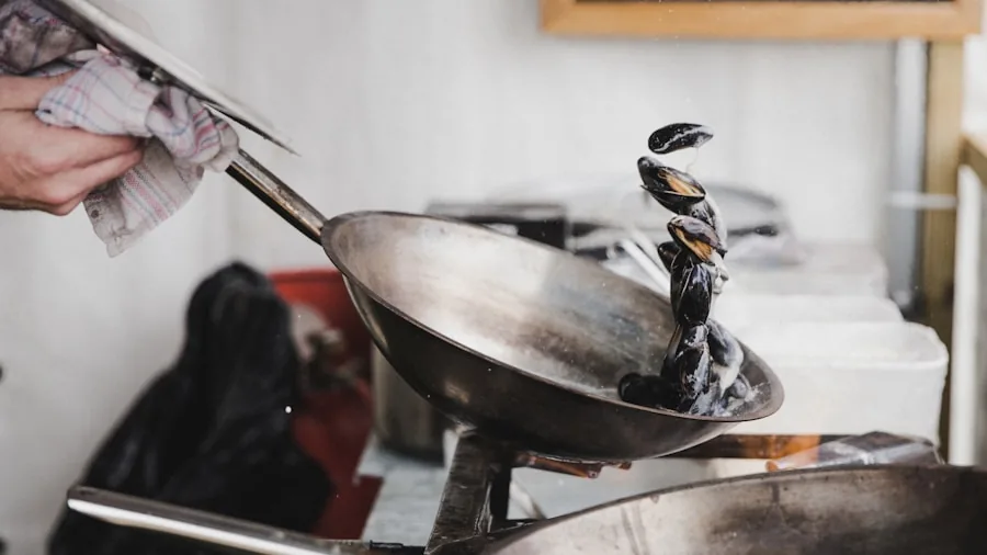 Professional chef seasoning a carbon steel wok in a modern kitchen with steam rising