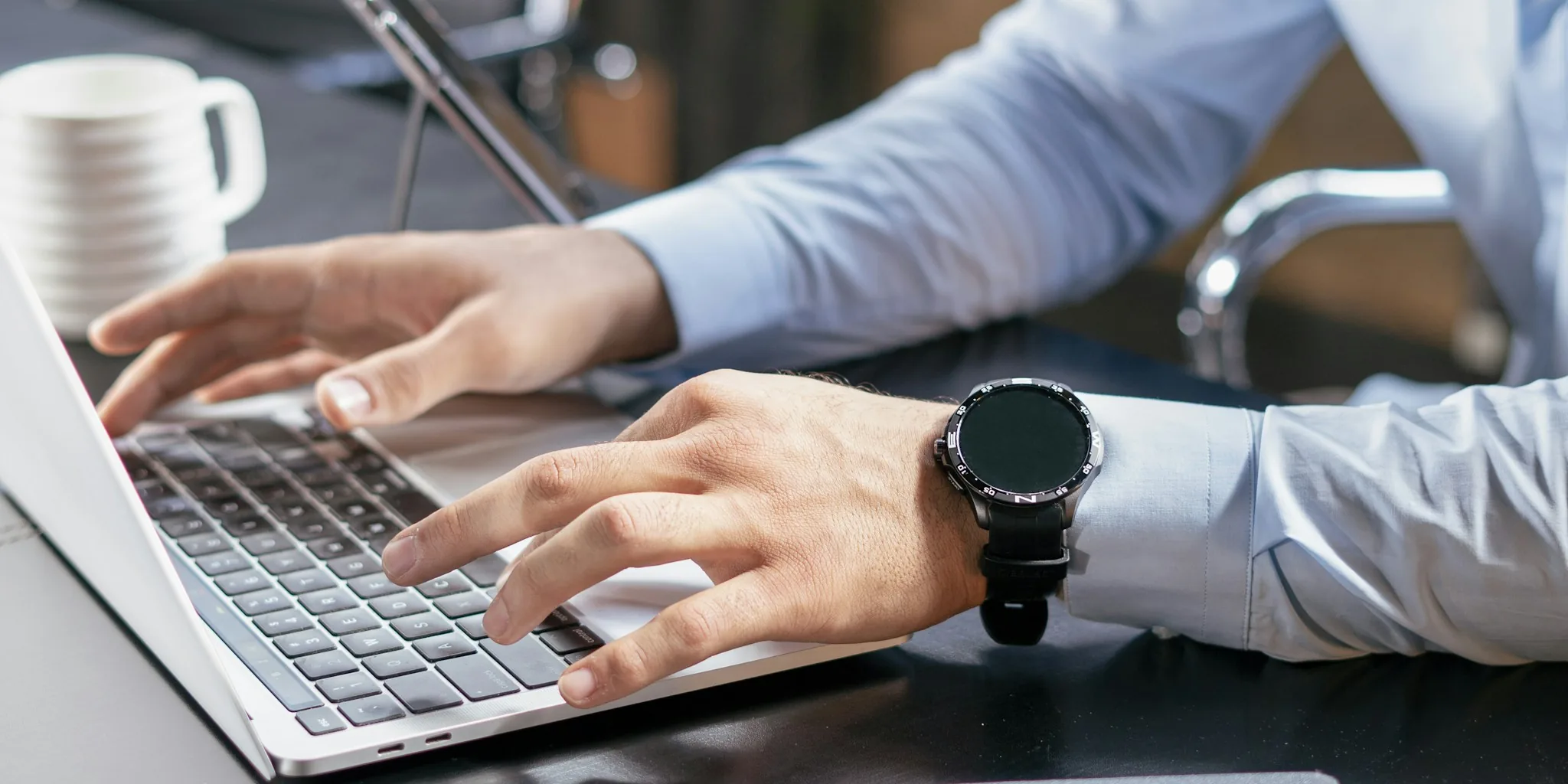 Professional focused on work using laptop at desk with natural lighting