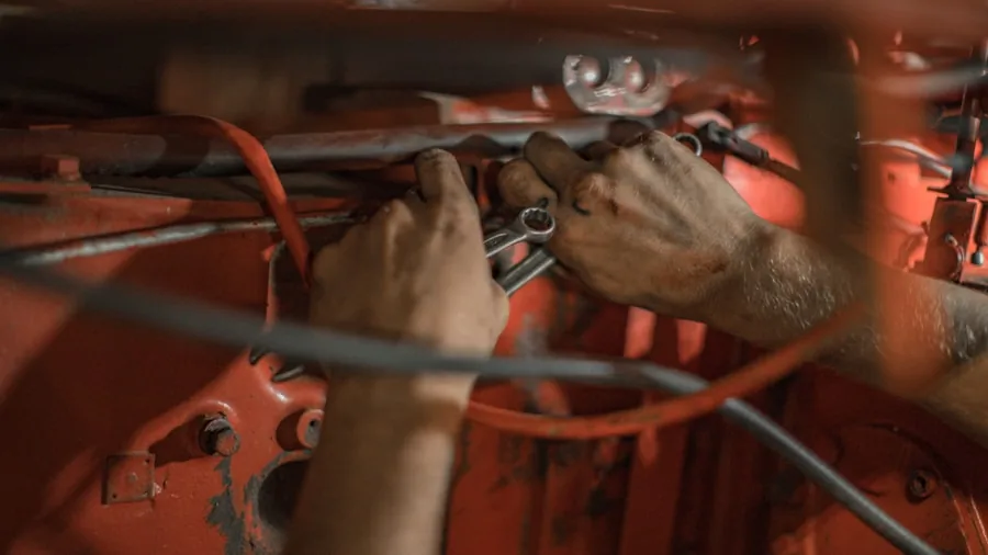 Professional mechanic in work apron organizing and selecting tools in organized garage workshop