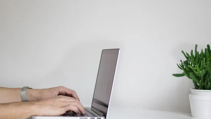 Professional using wireless keyboard and mouse at home office desk setup
