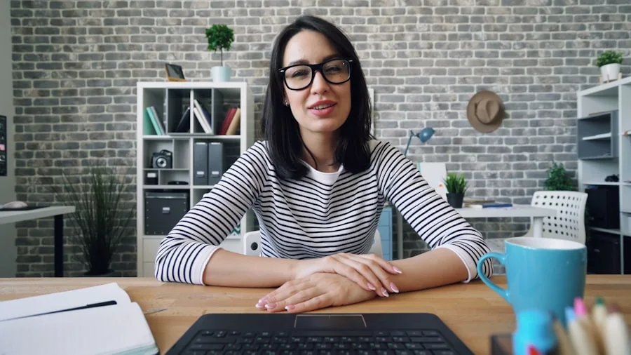 Professional working at desk during video call with laptop camera in focus